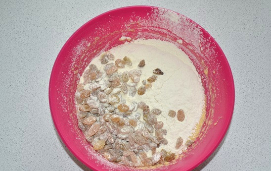 1. Этап. Тесто для куличей на сухих дрожжах: В тесто постепенно добавляйте муку и изюм. Замесите тесто.