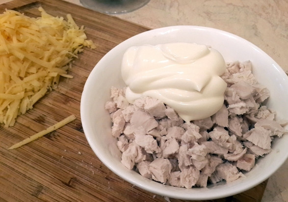 1. Этап. Салат с курицей, ананасами и грецкими орехами: Отварную куриную грудку нарезаем кубиками, смешиваем с майонезом.