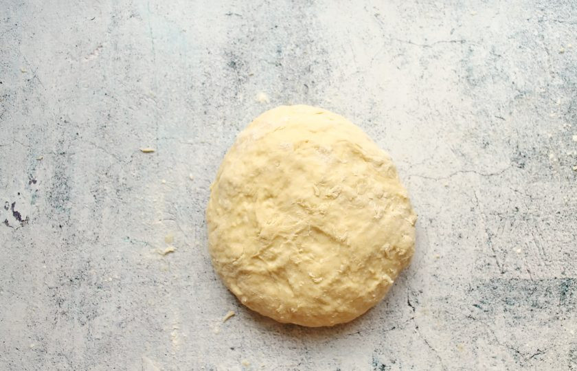 1. Этап. Пирожки на кефире и сметане: Муку смешайте с содой и просейте в смесь. Замесите мягкое, слегка липкое, однородное тесто.