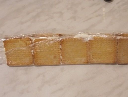 1. Этап. Торт Домик без выпечки: 5. Аккуратно, вместе с пленкой заверните оба края к центру, сформировав таким образом избушку. Отправьте тортик на ночь в холодильник.