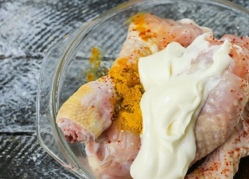 1. Этап. Ножки в духовке: Выкладываем куриные голени в отдельную емкость, засыпаем специями и майонезом, хорошенько все перемешиваем. Заливаем все соевым соусом, отправляем в холодильник на 2 часа. Тем временем отвариваем в кипящей подсоленной воде картофель на протяжении 3-5 минут, лук обжариваем до золотистости на сковороде.