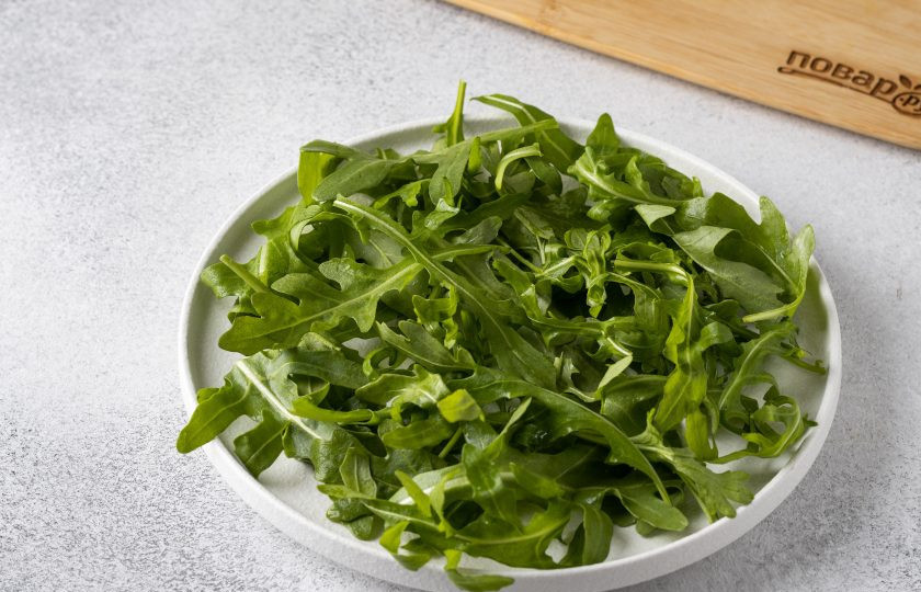 1. Этап. Салат с рукколой и персиками: Рукколу промойте и обсушите. Длинные хвостики можно оторвать. Выложите рукколу в тарелку.