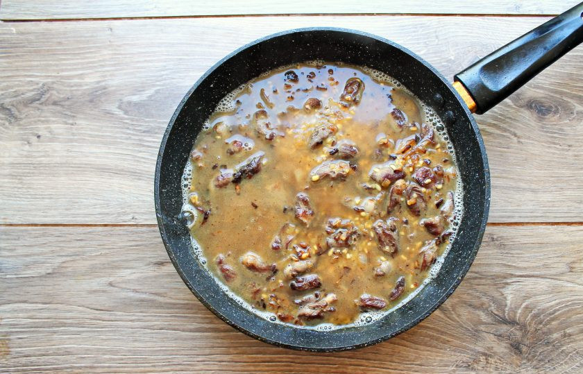 1. Этап. Булгур с куриными сердечками: Влейте в сковороду кипяток и перемешайте, доведите до кипения.