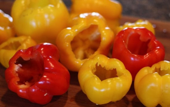 1. Этап. Перец, фаршированный морковью: 2. Отрежьте шляпки у перцев, затем удалите семена и промойте внутри. Очистите морковь и натрите ее на крупной терке.