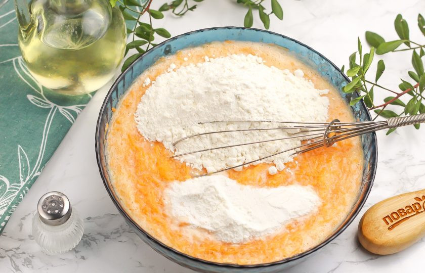 1. Этап. Морковный кекс с медом: Всыпьте разрыхлитель и пшеничную муку по частям. Вмешайте их в массу, но не взбивайте.