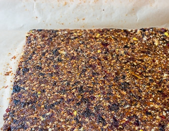 1. Этап. Веганские батончики из сухофруктов: Выкладываем массу между двумя листами пергаментной бумаги или пищевой пленки и раскатываем в прямоугольник нужной вам толщины. Затем подсушим либо в духовке (при небольшой температуре и с вентилятором), либо просто в сухом месте, переворачивая несколько раз в день для равномерной просушки.