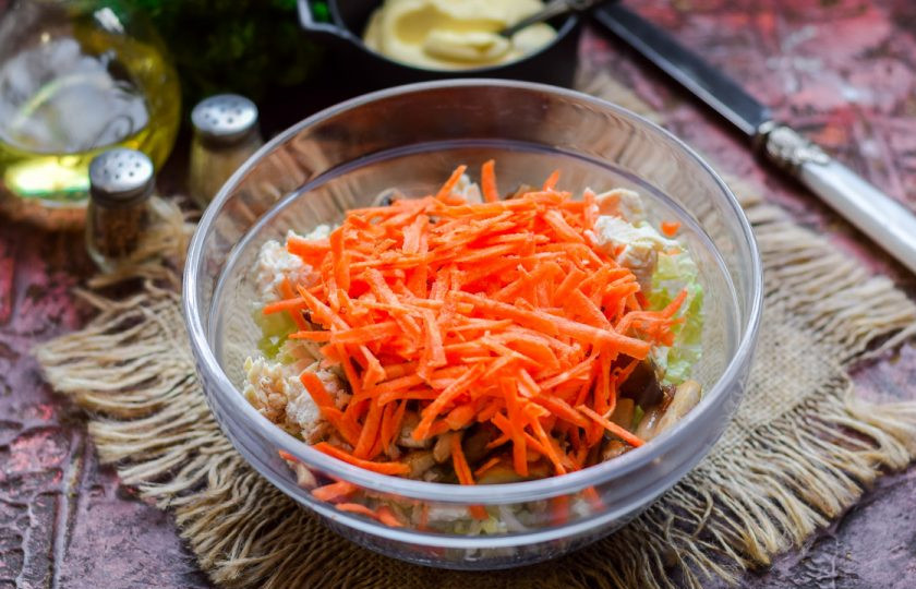 1. Этап. Салат Переполох: Морковь очистите, сполосните, натрите стружкой и добавьте в салат.