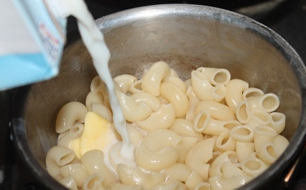 1. Этап. Макароны для детей: Готовые макароны откиньте на дуршлаг, позвольте воде стечь, затем отправьте их снова в кастрюлю. Добавьте масло и молоко.