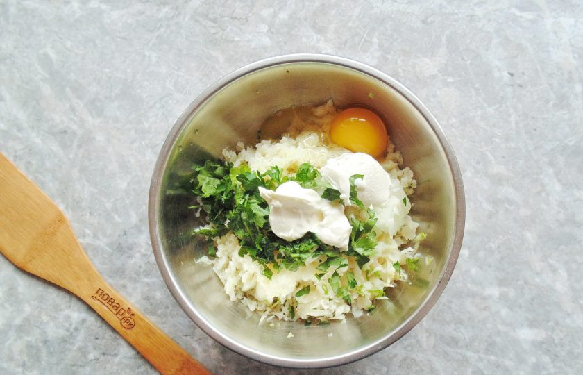 1. Этап. Котлеты из кабачка и цветной капусты: Разбейте в миску яйцо и добавьте сметану. Посолите и поперчите по вкусу.