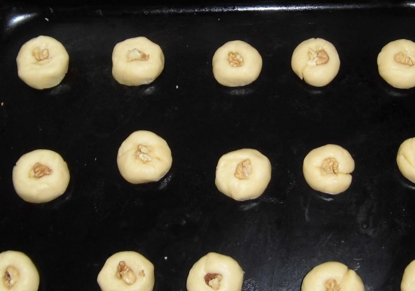 1. Этап. Восточное печенье: 4. От общей массы мягкого теста отщипываю небольшие кусочки, скатываю каждый в шарик и выкладываю на противень, чищу грецкие орехи, внутрь каждого печенья кладу один орешек.