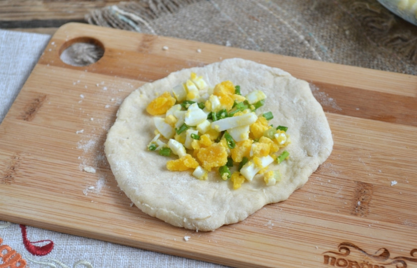 1. Этап. Пирожки с луком на кефире: Отрежьте небольшой кусок теста, раскатайте его, выложите в центр начинку и закройте пирожок, хорошенько защипнув края.