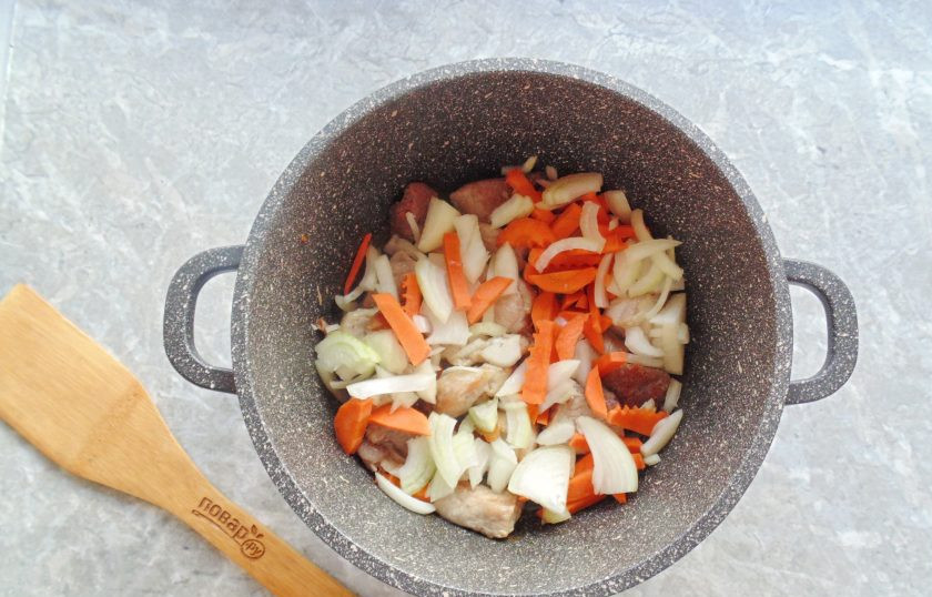 1. Этап. Мясо с капустой и яблоками: Лук и морковь очистите и помойте. Нарежьте соломкой морковь, а лук полукольцами. Добавьте к мясу. Налейте еще немного масла и жарьте овощи с мясом 5-7 минут, периодически перемешивая.