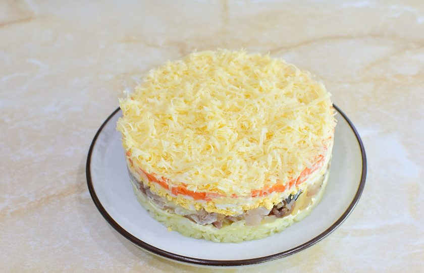 1. Этап. Салат Мимоза с копчёной скумбрией: Последним слоем выложите тертый сыр и аккуратно снимите сервировочное кольцо. Готовый салат немного охладите перед подачей и украсьте на свой вкус.