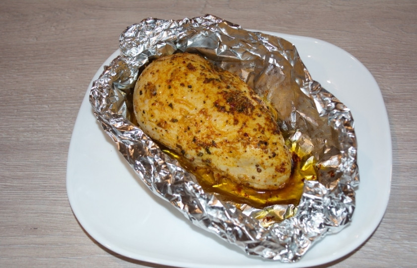 1. Этап. Куриная грудка под соусом: Приподнимите края и соедините их, придав фольге форму ложочки. Перед запеканием полейте мясо двумя столовыми ложками растительного масла. Так мясо не станет сухим и станет равномерно румяным. Разогрейте духовку на 200 градусов и запекайте куриное филе в духовке 1 час.