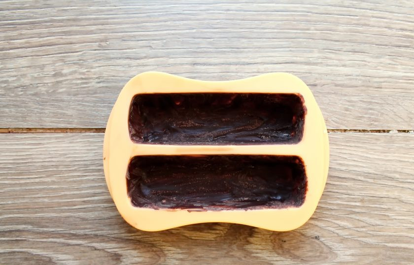 1. Этап. Глазированные сырки со сгущенкой: Нанесите шоколад, в два слоя на дно и бока формочек. Уберите их в холодильник, чтобы шоколад застыл.