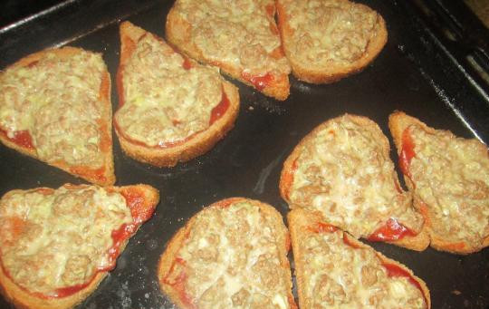 1. Этап. Бутерброды с фаршем в духовке: Сверху выкладываем фарш и помещаем бутерброды на противень. Запекаем в духовке до готовности, температура 220 градусов.