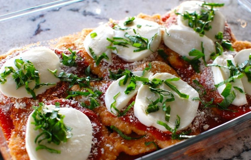 1. Этап. Куриные грудки с сыром в духовке: 11. Нарежьте ломтиками моцареллу и выложите поверх мяса, добавьте измельченный свежий базилик.