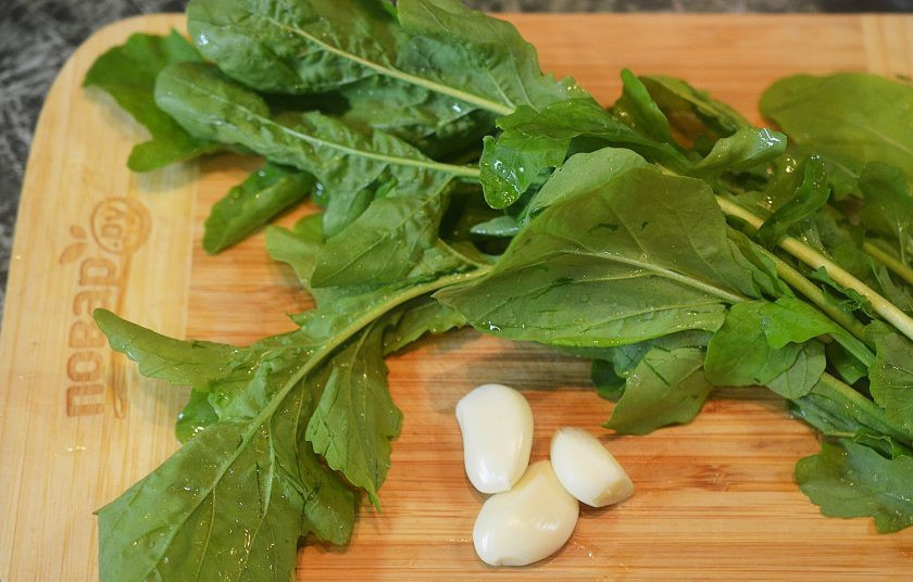 1. Этап. Сосиски-гриль с соусом песто из руколлы: Рукколу помойте, обсушите, чеснок почистите.