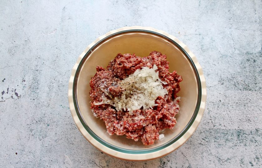 1. Этап. Котлеты из мраморной говядины: Оставшийся репчатый лук мелко порежьте и выложите в фарш. Все посолите и поперчите.