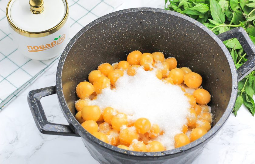 1. Этап. Компот из белой черешни на зиму: Пересыпьте черешню в казан или кастрюлю, добавьте сахарный песок и пару щепоток ванильного сахара.