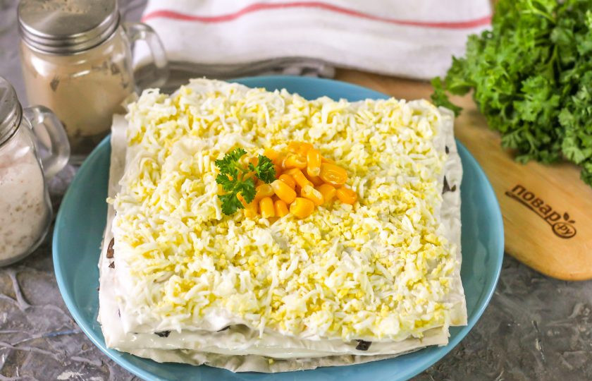 1. Этап. Закусочный торт Наполеон с курицей и грибами: Снова повторите слой лаваша с отварным куриным мясом, затем с шампиньонами и так до тех пор, пока не закончится начинка. Очистите отварные куриные яйца от скорлупы и промойте в воде. Натрите на терке с мелкими ячейками. Покройте блюдо последним смазанным лавашом, а его - присыпьте измельченной яичной массой. Украсьте закусочный торт по желанию: свежей зеленью, консервированной кукурузой, обжаренными грибами и т.д. Поместите его минимум на 30 минут в холодильник для пропитывания.
