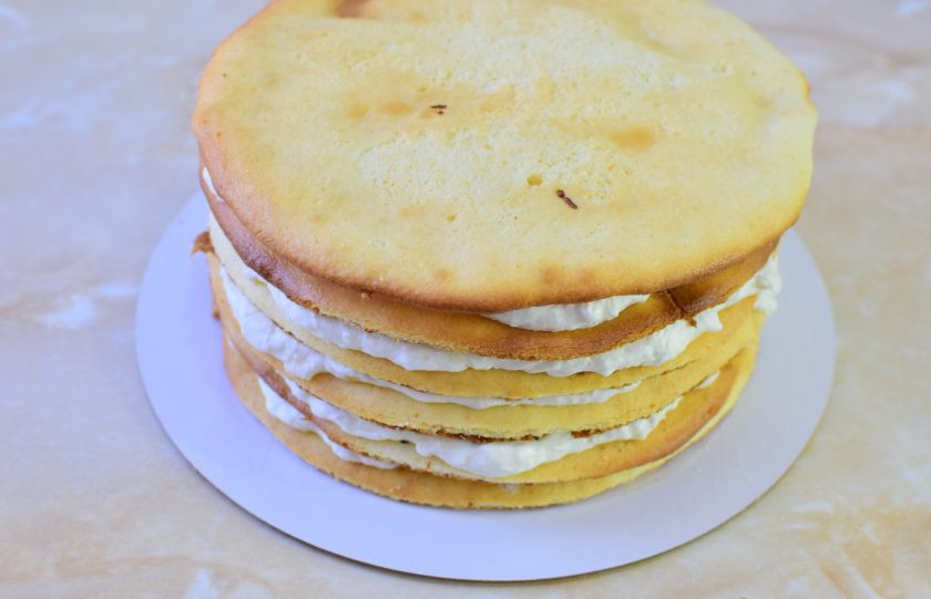 1. Этап. Торт «Молочная девочка» с бананами: Так промажьте все коржи. Для придания формы оберните торт ацетатной пленкой и оденьте кольцо для торта. Верхние коржи прижмите и смажьте кремом. Уберите торт в холодильник на ночь. Он настоится и пропитается.