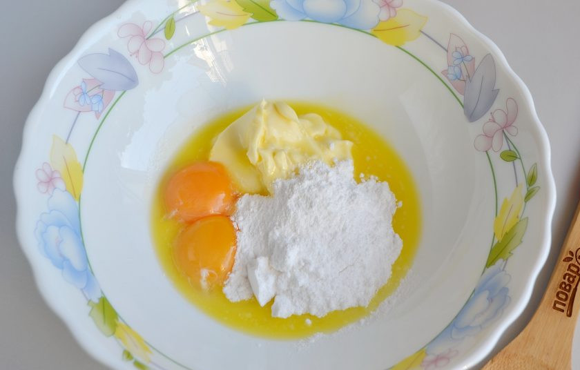 1. Этап. Ореховые пирожные: 2. Растопите сливочное масло, только не кипятите, я ставила в микроволновку на пол минутки, просто чтоб масло стало мягким. Добавьте к маслу два желтка, сахарную пудру, хорошо перемешайте ложкой.