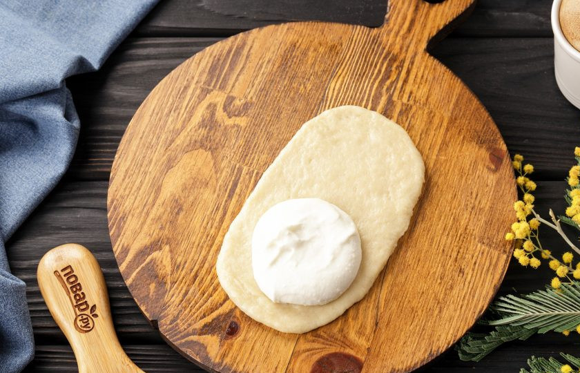 1. Этап. Сочни по ГОСТу: На присыпанном мукой столе раскатайте каждую часть теста в овальную лепешку толщиной около 5 мм., не больше. На одну половину раскатанного теста выложите около 1,5 ст.л. начинки, немного не доходя до краев. Если начинка у вас густая, разровняйте ложкой.