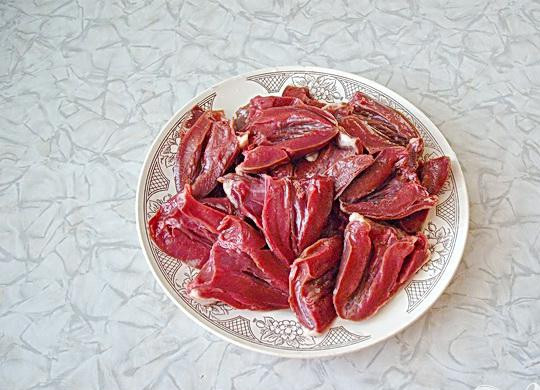 1. Этап. Тушеные индюшиные сердечки: 2. Выбирать сердечка для приготовления блюда надо очень внимательно. Если сердечка охлажденные, то такой вариант будет самым лучшим для приготовления, так как кровь в таких случаях не успевает свернуться внутри сердечек, хотя и замороженные сердца так же будут пригодны к приготовления блюда. Льда на сердечках быть не должно. Должны они быть одного цвета и ровными. Сердечки разрезаем пополам, трубочки удаляем. Затем мясо хорошо промываем.