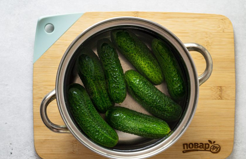 1. Этап. Консервированные огурцы с уксусом: Огурцы заранее помойте, замочите в холодной воде на 2-3 часа. Затем слейте воду и отрежьте кончики у огурцов с двух сторон.