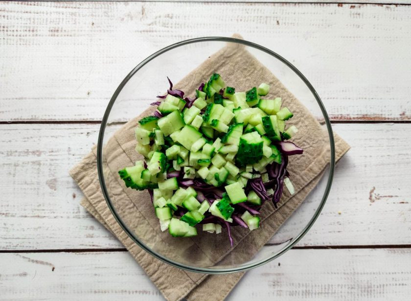 1. Этап. Салат с краснокочанной капустой и горошком: Огурец хорошо помойте под проточной водой, обсушите бумажным полотенцем, мелко нарежьте и добавьте к капусте.