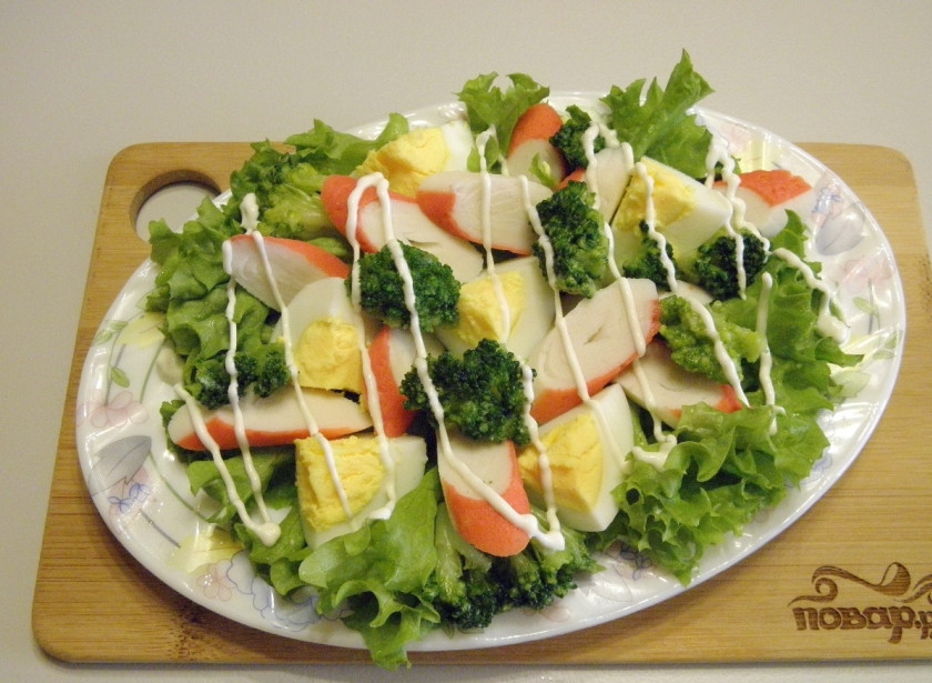 1. Этап. Салат с брокколи и крабовыми палочками: Разложите капусту брокколи. Посыпьте солью и орегано. Сделайте майонезную сеточку. Салат готов, приятного аппетита!