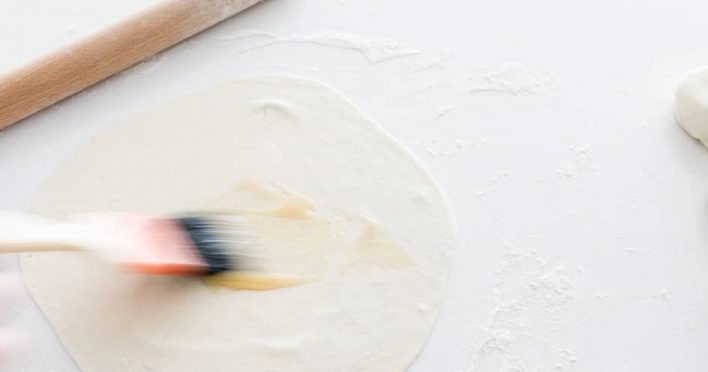 1. Этап. Жареные лепешки с зеленым луком: 4. Смажьте тонкую лепешку столовой ложкой поджаренного кунжутного масла.