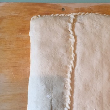 1. Этап. Кулебяка с рисом, луком, яйцами, рыбой: Сложить края кулебяки конвертом и хорошо защипать края.