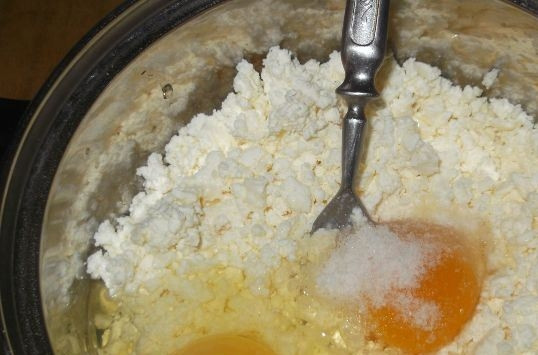 1. Этап. Творог для вареников: Разотрите творог вилкой так, чтобы там не осталось больших комков. Затем вбейте по очереди сырые куриные яйца. Добавьте соль. Тщательно перемешайте все ингредиенты.