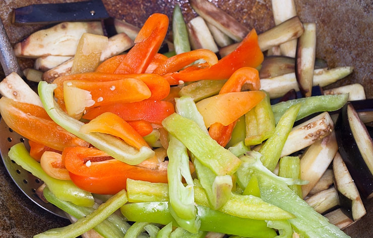 1. Этап. Баклажаны в казане на костре: Уберите из казана морковь с луком. Теперь в нём готовьте перец и баклажан (крупными кусками). Не забудьте влить масло.