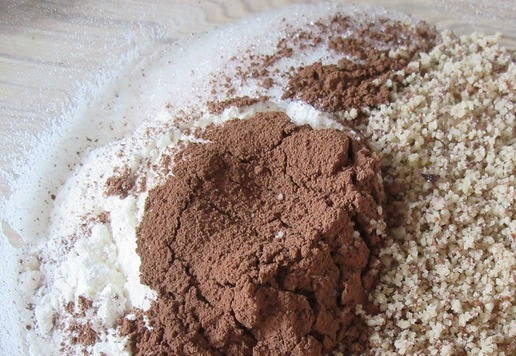 1. Этап. Шоколадный торт с ягодным желе: Для бисквита смешайте муку, разрыхлитель, какао-порошок, ванилин, измельченные орехи и сахар по вкусу. Перемешайте.