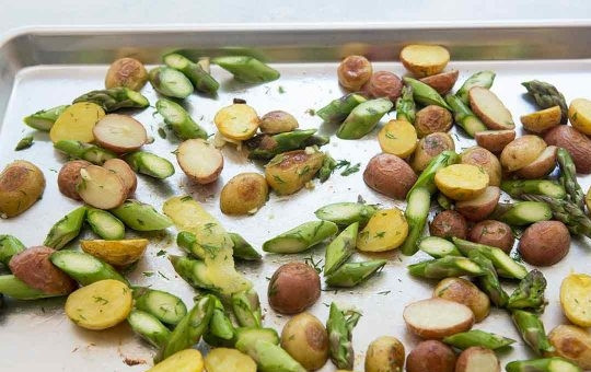 1. Этап. Рецепт семги в духовке с картошкой: Отправляем спаржу на противень к картошке, хорошо перемешиваем.