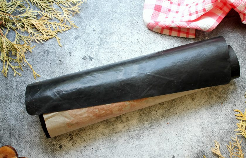 1. Этап. Рулет Красный бархат: Готовый бисквит достаньте из духовки и переверните на чистый пергамент. Отделите пергамент, на котором он пекся, накройте вторым чистым пергаментом или ковриком для выпечки и сверните в рулет. Оставьте бисквит до полного его остывания.