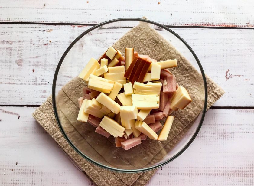 1. Этап. Салат София с копченым сыром: Копченый сыр нарежьте соломкой и добавьте к ветчине.