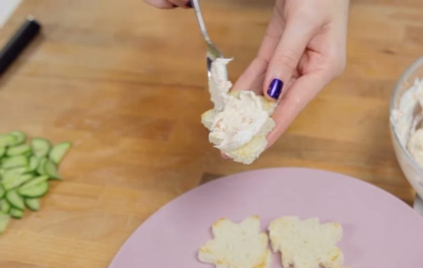 1. Этап. Тосты Елочки: 2. Хлеб для тостов вырежьте с помощью формочек-елочек и обжарьте на сухой сковороде до золотистой корочки с обеих сторон. Нанесите на тосты спред и выложите на них нарезанные полукольцами огурцы.