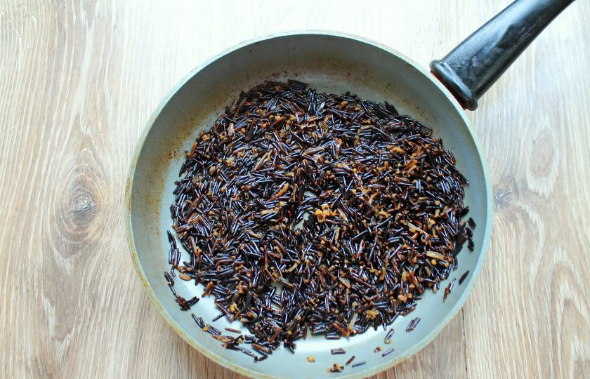 1. Этап. Черный рис с курицей: Черный рис промойте и выложите в глубокую кастрюлю. Залейте рис куриным бульоном, закройте крышкой и готовьте в течение 50-60 минут на медленном огне. Большинство рисинок должны раскрыться.