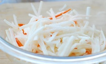 1. Этап. Редька по-корейски: Добавьте к натертым овощам все остальные ингредиенты. Тщательно перемешайте всё руками, сахар должен раствориться.