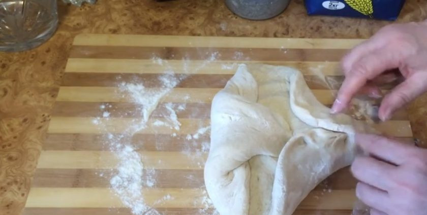 1. Этап. Хлеб из муки двух сортов: Аккуратно снимите пленку и выложите тесто на присыпанную мукой рабочую поверхность. Разделите тесто на 2 части, каждую часть округлите. Сформируйте хлеб овальной формы так, как вам удобно.