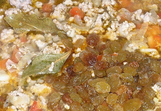 1. Этап. Аргентинский пирог с фаршем: Через пару минут добавьте изюм, перемешайте, тушите еще около получаса.