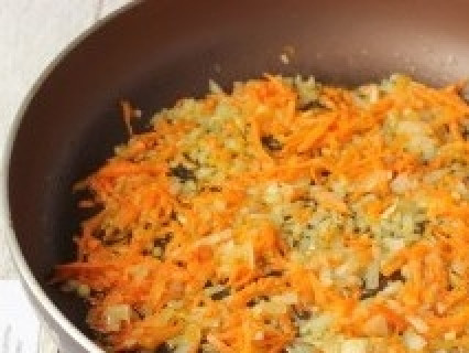 1. Этап. Рассольник из свинины: Обжариваем на подсолнечном рафинированном масле лук до прозрачности. Добавляем в сковороду к луку натёртую морковь. Перемешиваем и обжариваем на среднем огне.