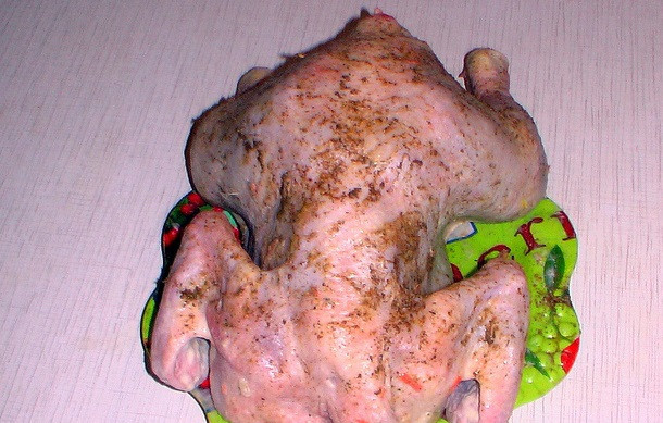 1. Этап. Курица в рукаве, фаршированная рисом: 4. Птицу вымыть, обсушить бумажным полотенцем и натереть специями (солью, перцем, приправами по вкусу). Поместить внутрь начинку.