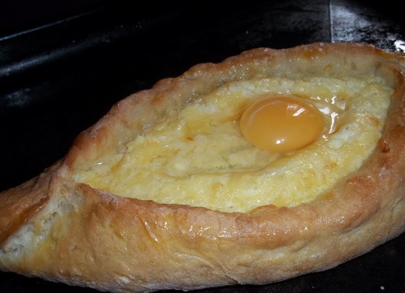 1. Этап. Аджарские хачапури Лодочка: 10. Взбитым желтком смажьте как следует тесто, а в центр разбейте аккуратно яйцо. Снова отправьте в духовку минуты на 3. Вот и весь секрет, как приготовить аджарские хачапури 