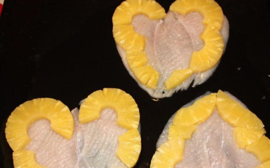 1. Этап. Куриные грудки с ананасом: Сердечки слегка отбейте и выложите на противень, смазанный маслом. Сверху выкладываем ананасы, разрезав и выложив их по контуру сердца.