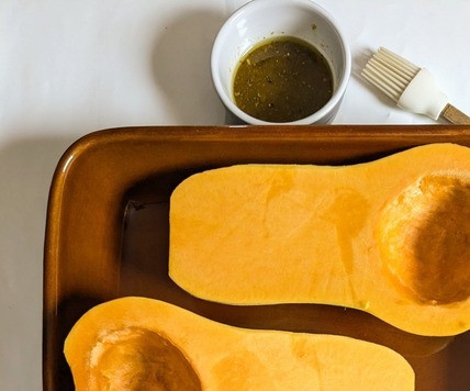 1. Этап. Тыква, фаршированная креветками и сыром: Тыкву сорта баттернат разрезать пополам, очистить от семян. Положить в форму надрезанной стороной вверх.